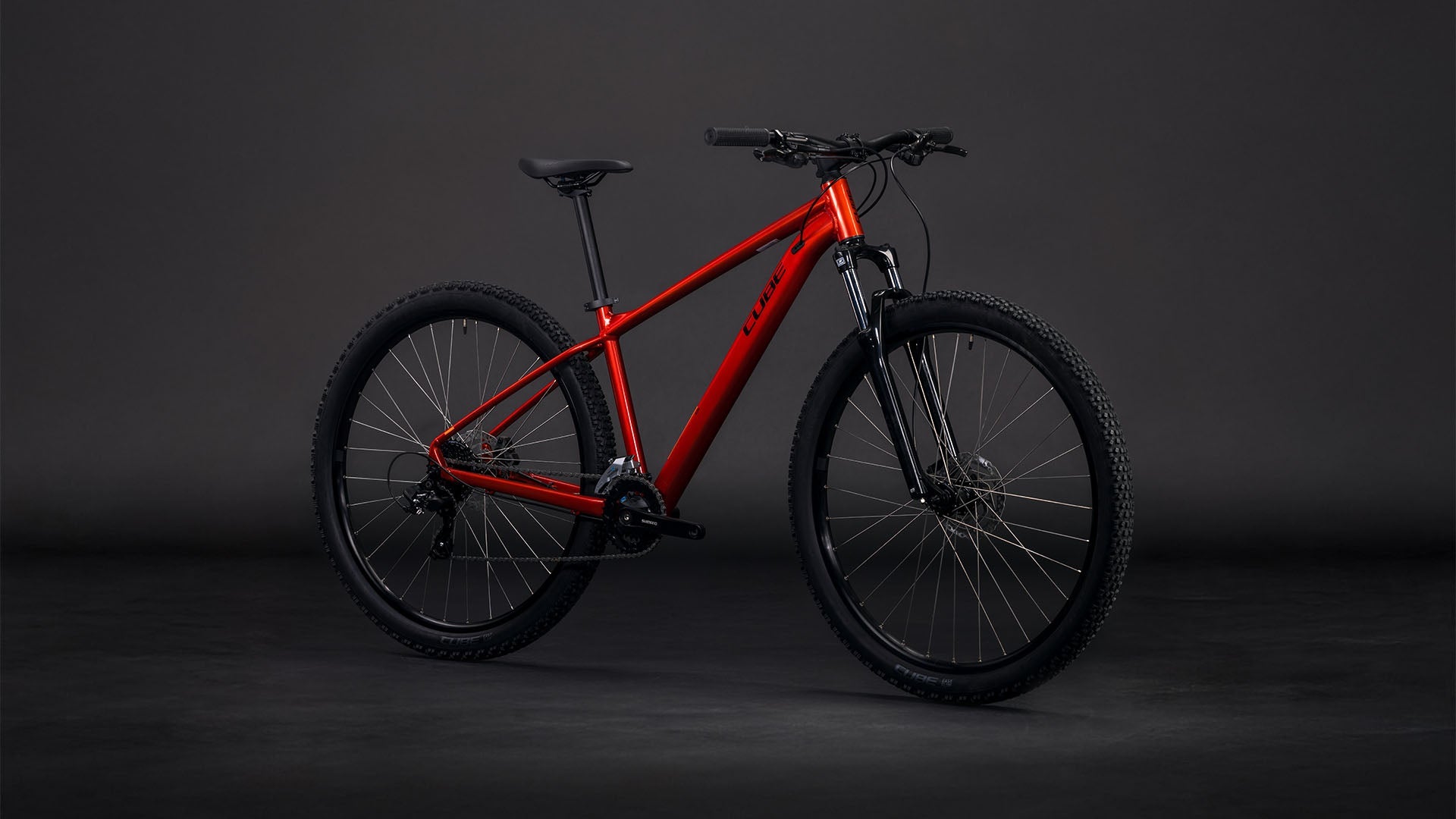 Bicicleta de montaña CUBE Aim ONE 2026 color sundowner & black vista lateral completa sobre fondo negro